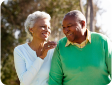 A young man is standing on a tennis court holding his shoulder and grimacing in pain. In his other hand he is holding a tennis racquet.