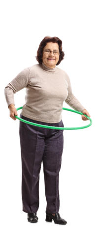 A senior woman stands with a hula hoop around her waist, holding it in her hands