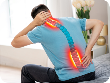 A man holds his neck and lower back in pain. The image of a spine is overlayed on the person's back and the painful areas are highlighted in red.